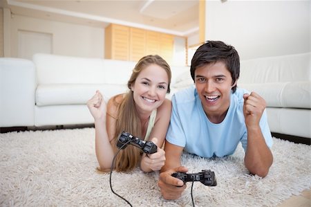 simsearch:400-04878558,k - Cheerful young couple playing video games in their living room Stock Photo - Budget Royalty-Free & Subscription, Code: 400-05746747