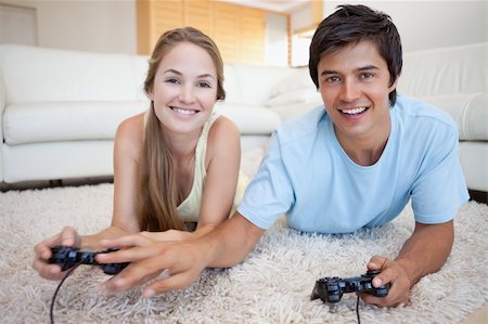 simsearch:400-05740058,k - Young couple playing video games in their living room Photographie de stock - Aubaine LD & Abonnement, Code: 400-05746742