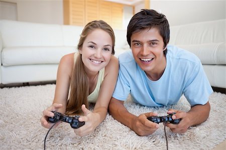 Smiling couple playing video games in their living room Stock Photo - Budget Royalty-Free & Subscription, Code: 400-05746743