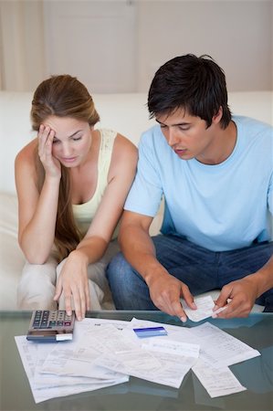 Portrait of a worried couple looking at their bills in their living room Stock Photo - Budget Royalty-Free & Subscription, Code: 400-05746753