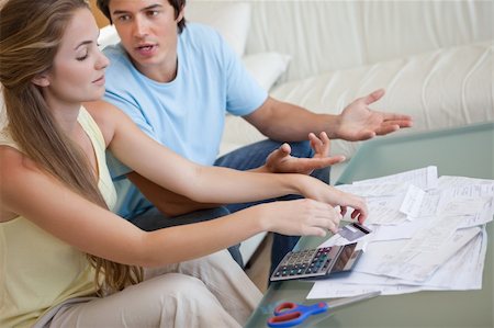 Couple having an argument about their bills in their living room Stock Photo - Budget Royalty-Free & Subscription, Code: 400-05746768