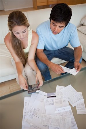 Portrait of a young couple looking at their bills in their living room Stock Photo - Budget Royalty-Free & Subscription, Code: 400-05746763