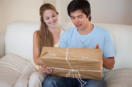 Young couple looking at a package in their living room Stock Photo - Budget Royalty-Free & Subscription, Code: 400-05746779