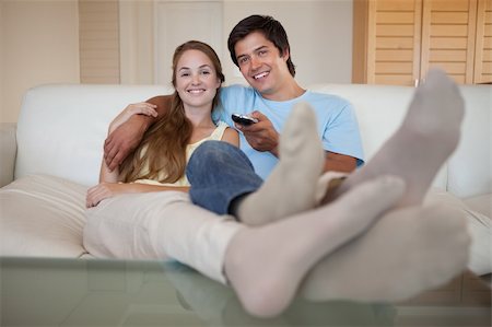 simsearch:400-05748052,k - Relaxed young couple watching television in their living room Foto de stock - Super Valor sin royalties y Suscripción, Código: 400-05746773
