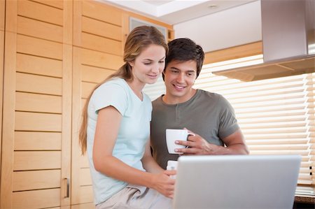 simsearch:400-05749531,k - Couple having tea while using a notebook in their kitchen Stock Photo - Budget Royalty-Free & Subscription, Code: 400-05746843