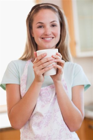 simsearch:400-04335902,k - Portrait of a woman drinking a cup of coffee in her kitchen Photographie de stock - Aubaine LD & Abonnement, Code: 400-05746898