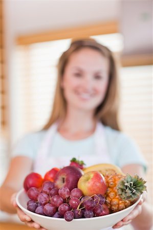 simsearch:400-05741507,k - Portrait of a young woman presenting a fruit basket with the camera focus on the object Stockbilder - Microstock & Abonnement, Bildnummer: 400-05746893