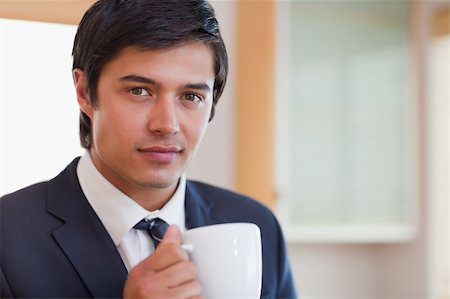 Close up of a handsome businessman drinking coffee in his kitchen Photographie de stock - Aubaine LD & Abonnement, Code: 400-05746916