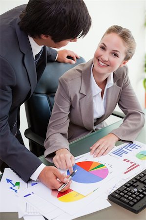 simsearch:400-04918393,k - Portrait of a smiling business team studying statistics in a meeting room Stock Photo - Budget Royalty-Free & Subscription, Code: 400-05746944