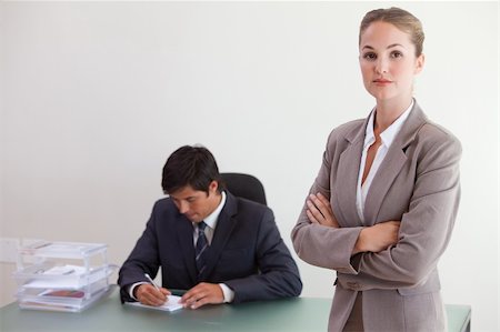 simsearch:400-04287075,k - Busineswosman posing while her colleague is working in an office Fotografie stock - Microstock e Abbonamento, Codice: 400-05746965