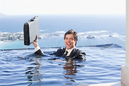 Businessman holding a briefcase in a swimming pool Stock Photo - Budget Royalty-Free & Subscription, Code: 400-05746967