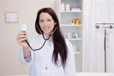 simsearch:400-05747031,k - Smiling young female doctor using stethoscope Photographie de stock - Aubaine LD & Abonnement, Code: 400-05747017