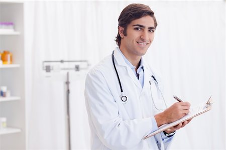 simsearch:400-05747031,k - Side view of smiling young doctor taking notes Photographie de stock - Aubaine LD & Abonnement, Code: 400-05747094