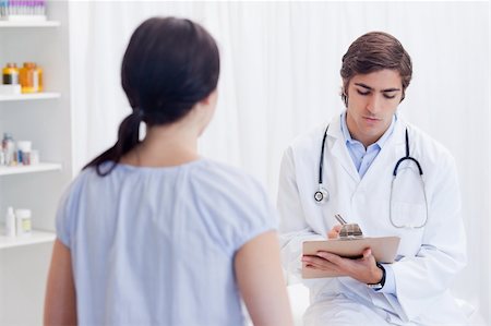 simsearch:400-05747031,k - Young physician talking notes while patient is talking Photographie de stock - Aubaine LD & Abonnement, Code: 400-05747106