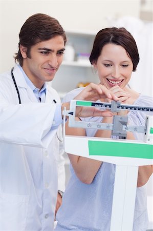 Young male doctor adjusting scale for his patient Stock Photo - Budget Royalty-Free & Subscription, Code: 400-05747137