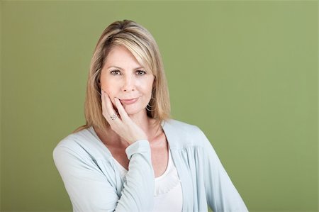 Mature Caucasian woman with hand on chin over green background Stock Photo - Budget Royalty-Free & Subscription, Code: 400-05747800