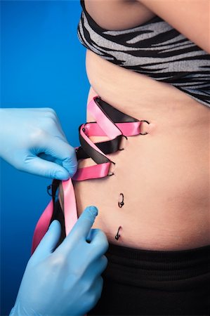 simsearch:400-05747842,k - Woman gets her body pierced with metal rings for corsetting Photographie de stock - Aubaine LD & Abonnement, Code: 400-05747836