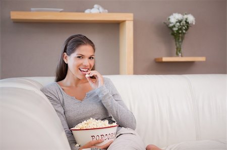 Young woman eating popcorn while watching movie Stock Photo - Budget Royalty-Free & Subscription, Code: 400-05747963