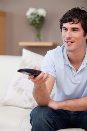 simsearch:400-05748048,k - Young man with remote control on the sofa Stockbilder - Microstock & Abonnement, Bildnummer: 400-05747974