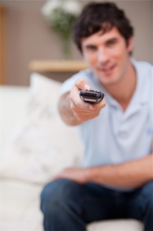 simsearch:400-05748048,k - Remote being used by young man on the sofa Stockbilder - Microstock & Abonnement, Bildnummer: 400-05747975
