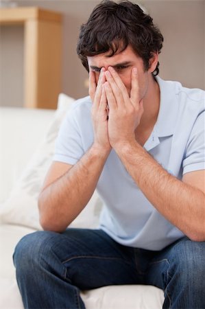 simsearch:400-06875322,k - Desperate young man sitting on the sofa Fotografie stock - Microstock e Abbonamento, Codice: 400-05747989