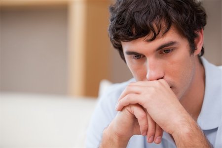 simsearch:400-06875322,k - Thoughtful young man in the living room Fotografie stock - Microstock e Abbonamento, Codice: 400-05747994