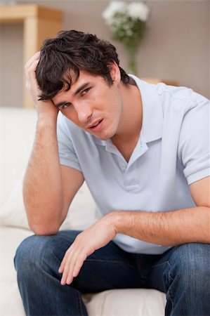 simsearch:400-06875322,k - Despaired young man sitting on the couch Stock Photo - Budget Royalty-Free & Subscription, Code: 400-05747991