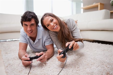 simsearch:400-05297936,k - Young couple playing video games on the floor Stock Photo - Budget Royalty-Free & Subscription, Code: 400-05748030