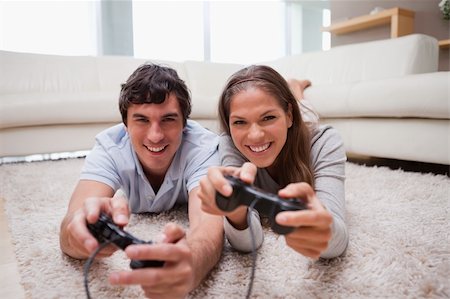 simsearch:400-05297936,k - Young couple playing video games in the living room Stock Photo - Budget Royalty-Free & Subscription, Code: 400-05748031