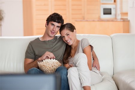 simsearch:400-05748048,k - Young couple with bowl on popcorn watching a movie on the sofa Stockbilder - Microstock & Abonnement, Bildnummer: 400-05748054
