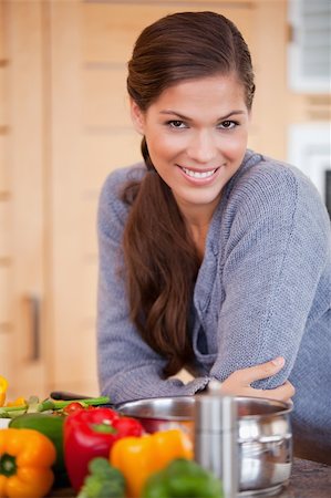 simsearch:400-05357667,k - Smiling young woman leaning against the kitchen counter Stock Photo - Budget Royalty-Free & Subscription, Code: 400-05748078