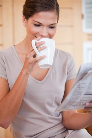 simsearch:400-04335902,k - Young woman taking a sip of coffee while reading newspaper Stock Photo - Budget Royalty-Free & Subscription, Code: 400-05748108