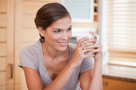 simsearch:400-04335902,k - Smiling young woman enjoying a cup of coffee Stock Photo - Budget Royalty-Free & Subscription, Code: 400-05748101