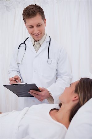 simsearch:400-05748268,k - Doctor standing next to his bedridden patient Stock Photo - Budget Royalty-Free & Subscription, Code: 400-05748264