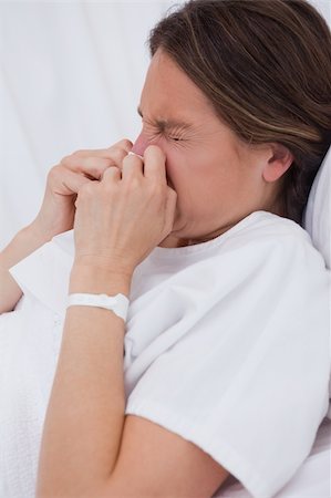 patient in hospital frustrated - Side view of woman in hospital bed sneezing Stock Photo - Budget Royalty-Free & Subscription, Code: 400-05748278