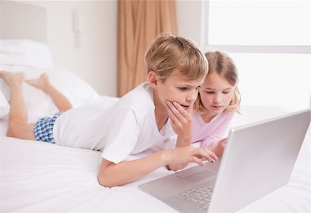 simsearch:400-05748382,k - Children using a laptop in a bedroom Fotografie stock - Microstock e Abbonamento, Codice: 400-05748377