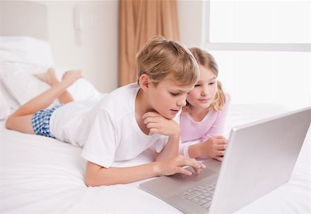 simsearch:400-05748382,k - Children using a notebook in a bedroom Fotografie stock - Microstock e Abbonamento, Codice: 400-05748378