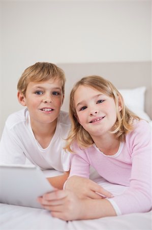 simsearch:400-05748382,k - Portrait of children using a tablet computer in a bedroom Fotografie stock - Microstock e Abbonamento, Codice: 400-05748389