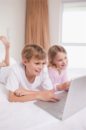 simsearch:400-04129482,k - Portrait of children using a notebook in a bedroom Photographie de stock - Aubaine LD & Abonnement, Code: 400-05748382