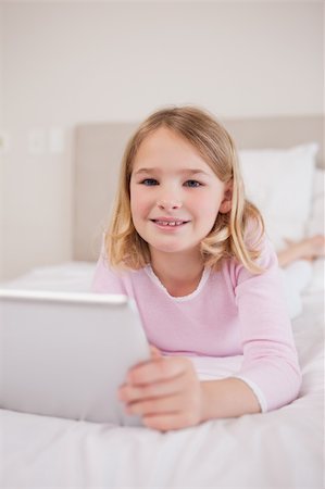 simsearch:400-05748382,k - Portrait of a girl using a tablet computer in her bedroom Fotografie stock - Microstock e Abbonamento, Codice: 400-05748394