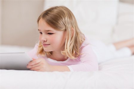 simsearch:400-05748382,k - Child using a tablet computer in a bedroom Fotografie stock - Microstock e Abbonamento, Codice: 400-05748398