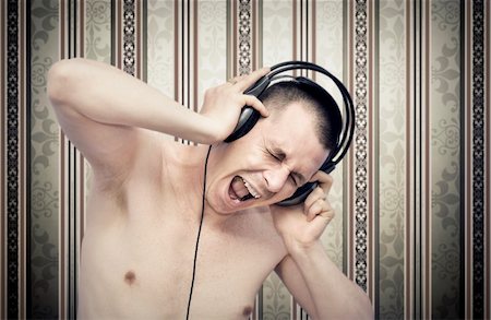 Young man enjoying music on headphones Stock Photo - Budget Royalty-Free & Subscription, Code: 400-05748462