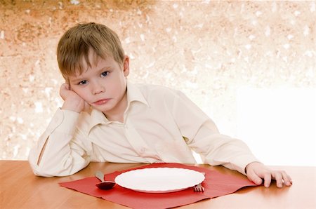 pensive child sits near an empty plate and  looks ahead Fotografie stock - Microstock e Abbonamento, Codice: 400-05748910