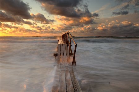 stormy beach scene - pier on a windy day at sunset Stock Photo - Budget Royalty-Free & Subscription, Code: 400-05749199