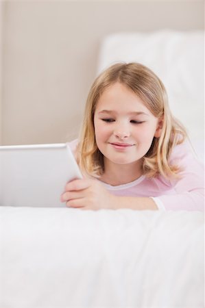 simsearch:400-05748382,k - Portrait of a smiling little girl using a tablet computer in a bedroom Fotografie stock - Microstock e Abbonamento, Codice: 400-05749377