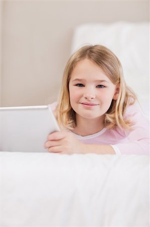 simsearch:400-05748382,k - Portrait of a cute little girl using a tablet computer in a bedroom Fotografie stock - Microstock e Abbonamento, Codice: 400-05749378