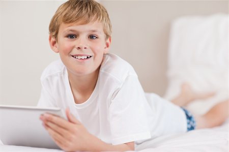 simsearch:400-05748382,k - Boy using a tablet computer in a bedroom Fotografie stock - Microstock e Abbonamento, Codice: 400-05749379