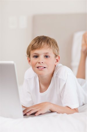 simsearch:400-04129482,k - Portrait of a boy using a laptop in a bedroom Photographie de stock - Aubaine LD & Abonnement, Code: 400-05749385