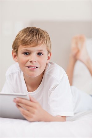 simsearch:400-05748382,k - Portrait of a boy using a tablet computer in a bedroom Fotografie stock - Microstock e Abbonamento, Codice: 400-05749380