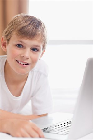 simsearch:400-04129482,k - Portrait of a young boy using a laptop in a bedroom Photographie de stock - Aubaine LD & Abonnement, Code: 400-05749390